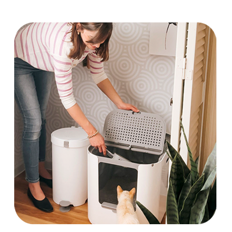 Woman interacting with a pet waste management system in a home setting
